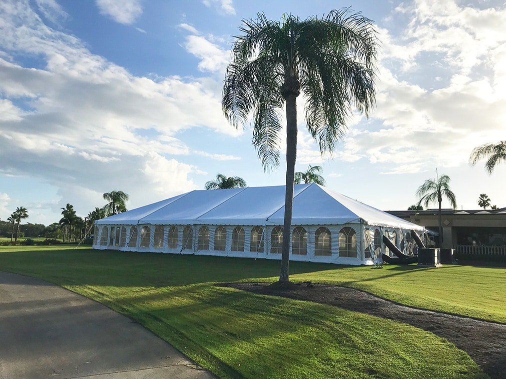Large white event tent installed on a landscaped lawn