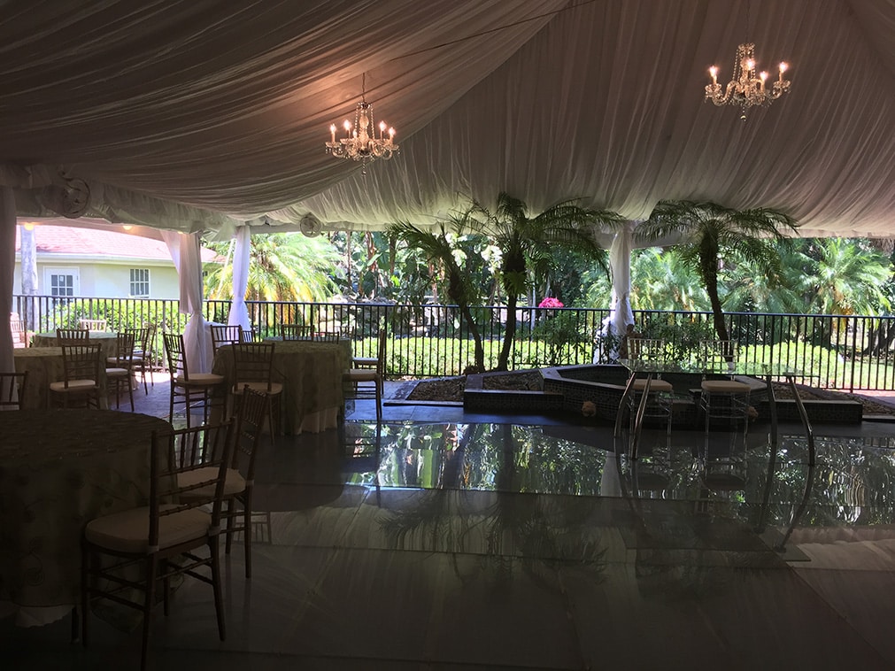 Evening tented event with chandeliers and a draped ceiling