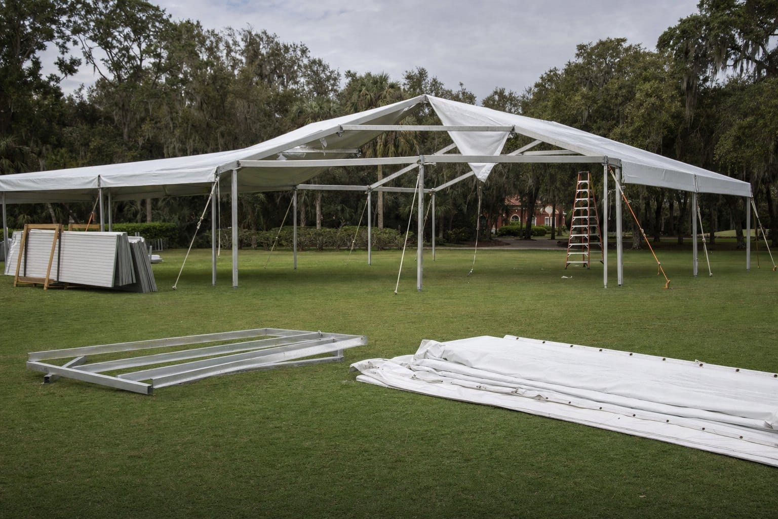 Creative Events & Rentals installing a white frame event tent on a Southwest Florida lawn