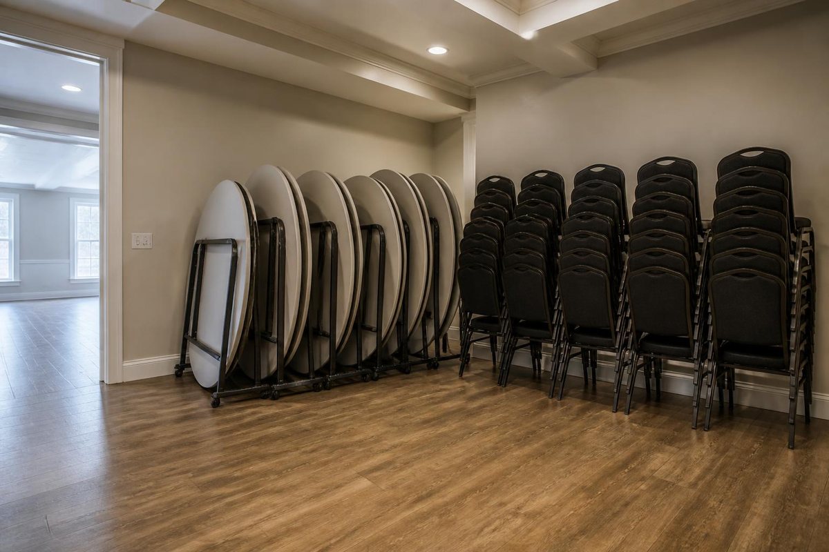 Folded tables and stacked chairs staged inside a venue