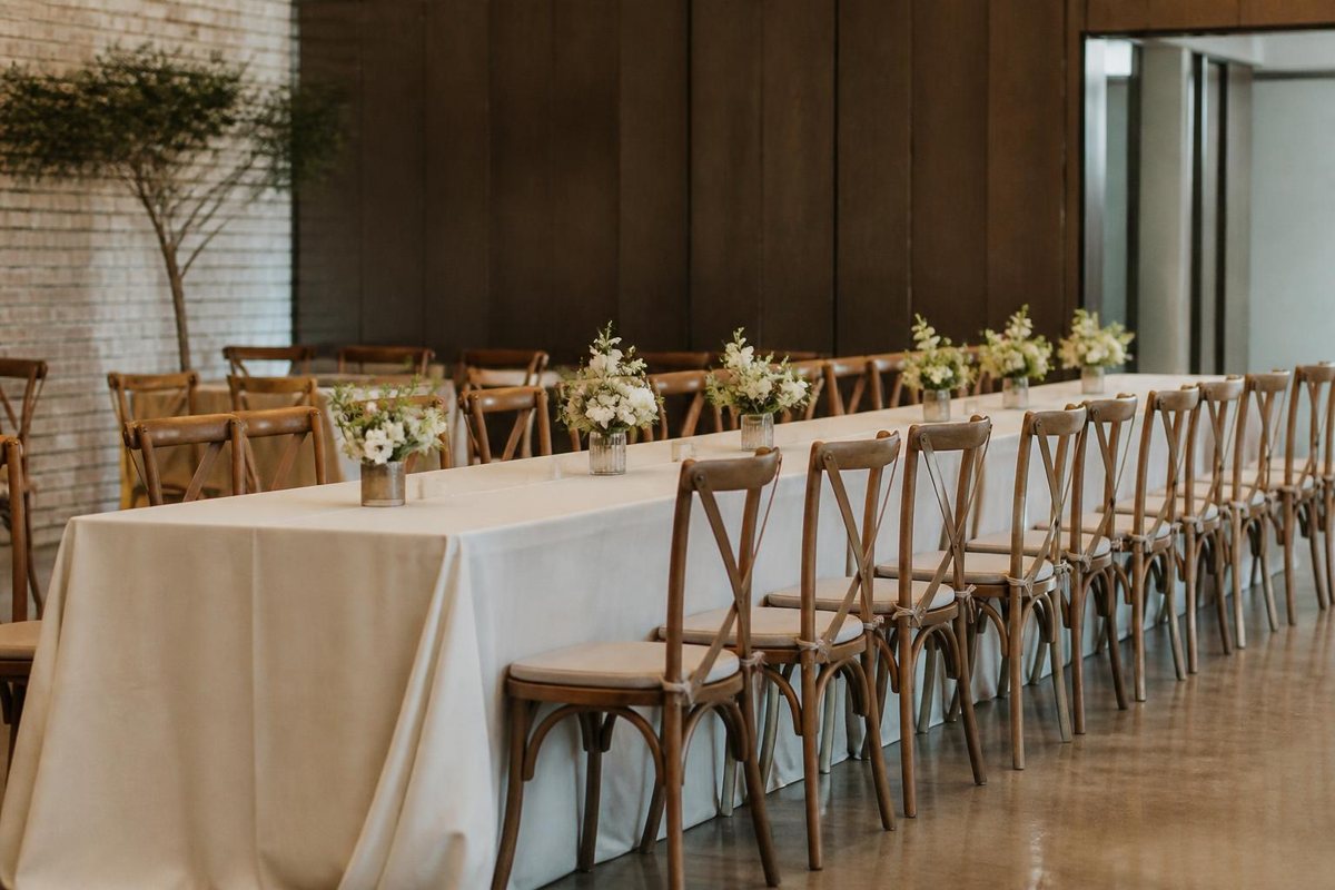 Long rectangular reception table with evenly spaced chairs