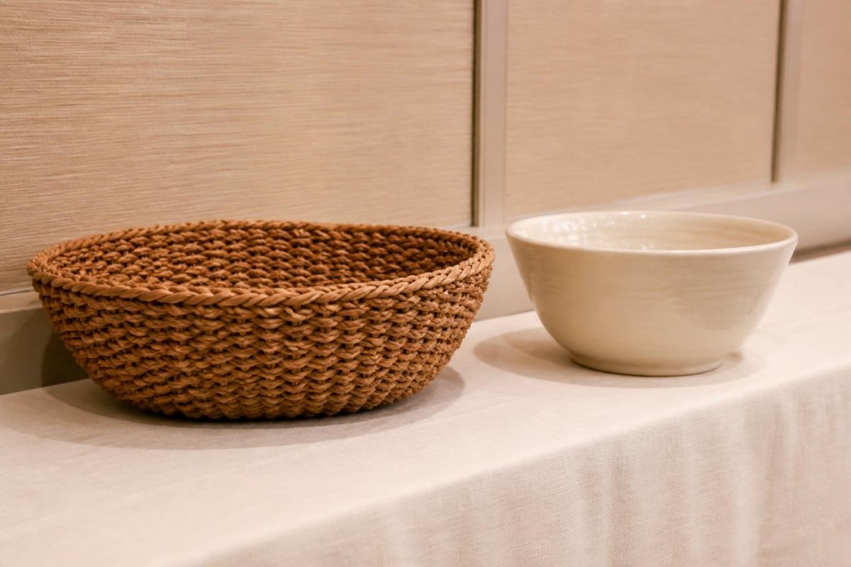 Woven basket and ceramic bowl on an auction display table