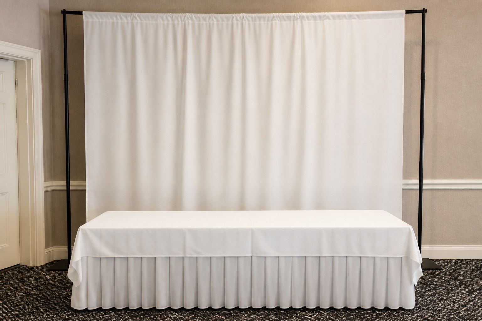 White drape backdrop on an adjustable pipe stand behind a skirted table