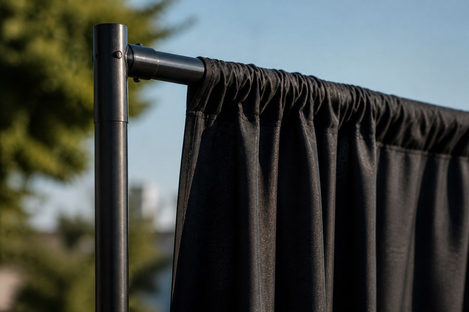 Close view of a pipe and drape upright with a crossbar and gathered black fabric